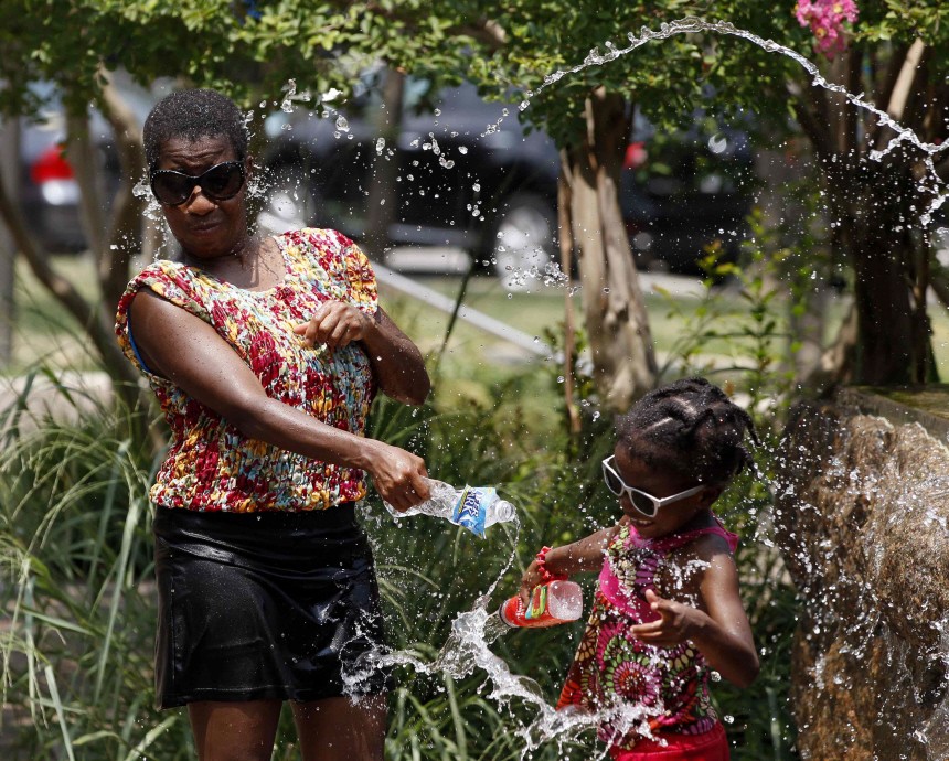 Washington resident squirts water out of bottles while cooling off in the heat in Washington