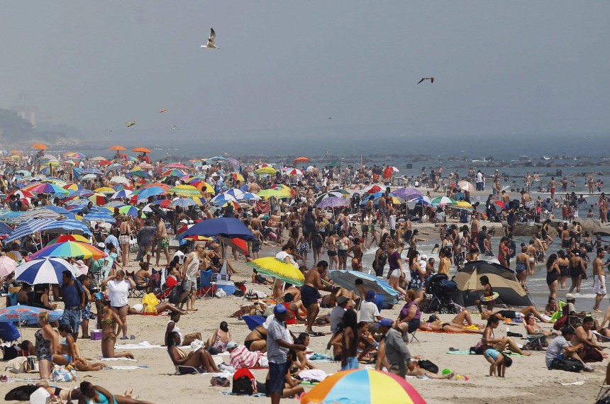 People lay on the beach at Coney Island in the Brooklyn borough of New York