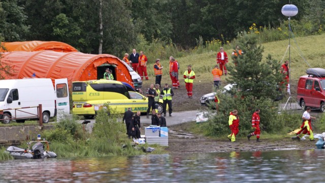 Rescue workers set up a camp across a lake, opposite the small, wooded island of Utoeya