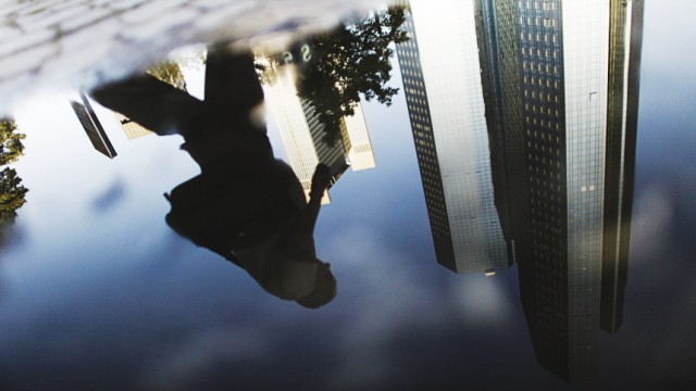 Headquarters of Deutsche Bank are reflected in a puddle in Frankfurt