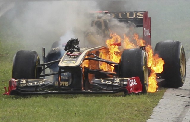 Renault Formula One driver Nick Heidfeld of Germany tries to leave his burning car during the Hungarian F1 Grand Prix at the Hungaroring circuit near Budapest