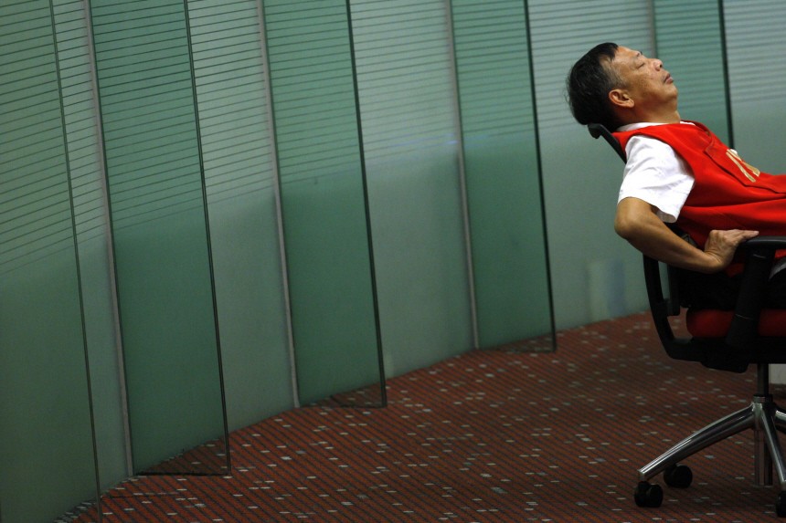 A floor trader takes a break inside the trading hall of the Hong Kong Stock Exchange