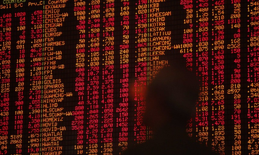 An investor monitors stock market prices in Kuala Lumpur