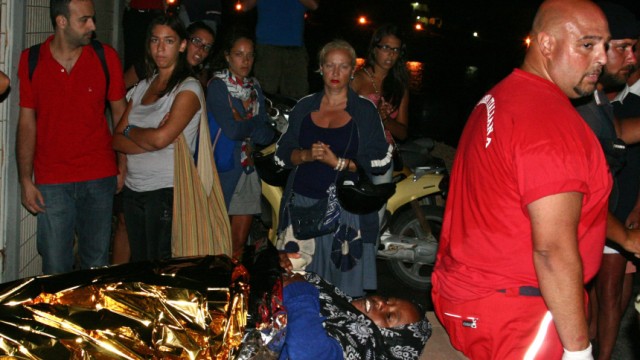 Drama im Mittelmeer: Eine entkräftete Frau wird auf einer Trage auf die Insel Lampedusa gebracht.