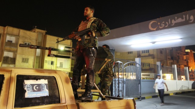 Rebel fighters stand guard outside Al-Galah hospital in Benghazi