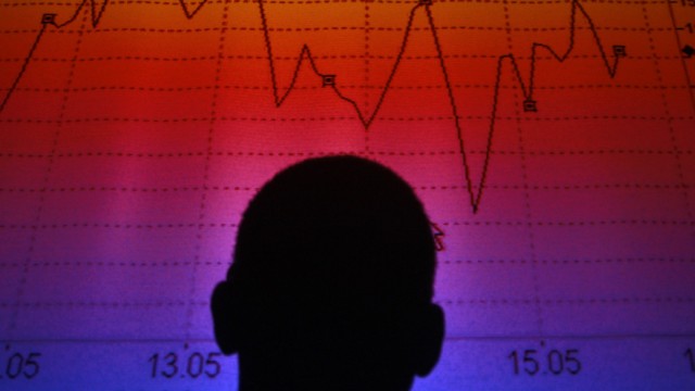 File photo illustration shows a man silhouetted in front of an electronic board showing the FTSE MIB Index in Rome