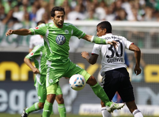 Bayern Munich's Luiz Gustavo competes for the ball with VfL Wolfsburg's Hasan Salihamidzic during their German first division Bundesliga soccer match in Wolfsburg