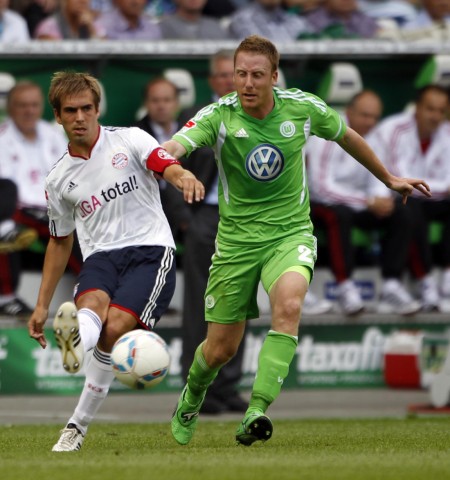 Bayern Munich's Lahm competes for the ball with VfL Wolfsburg's Ochs during their German first division Bundesliga soccer match in Wolfsburg