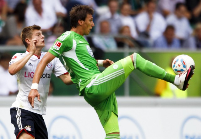 Bayern Munich's Kroos competes for the ball with VfL Wolfsburg's Mandzukic during their German first division Bundesliga soccer match in Wolfsburg