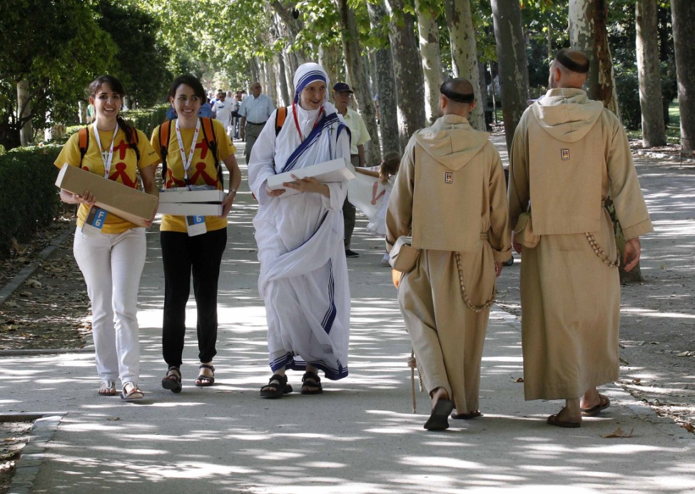 Two pilgrims and a nun walk by two monks at Madrid's Retiro park on the first day of the World Youth Day meeting in Madrid