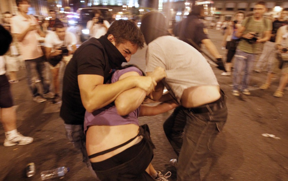 Policemen scuffle with protesters during a demonstration against what they claim is the expensive cost of the papal visit in central Madrid coinciding with the second day of the World Youth Day meeting