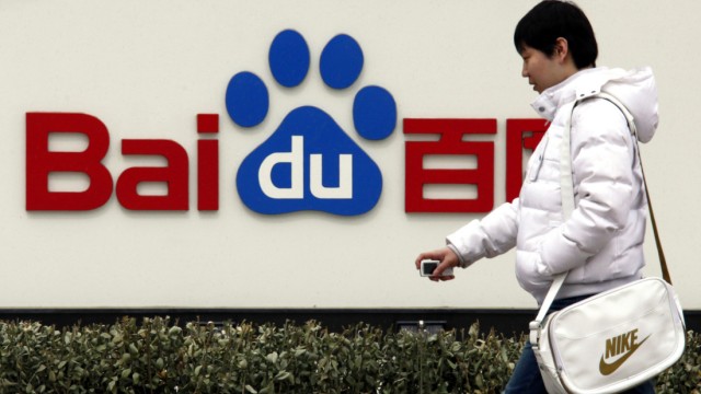 File photo of pedestrian walking past the company logo of Baidu located outside their headquarters in Beijing