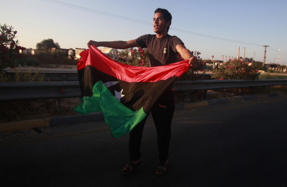 A man waves the Libyan rebel flag during a celebration in ithe town of Maia after fighters pushed to within 25 kms (15 miles) of Tripol