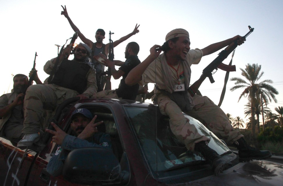 Libyan rebel fighters ride through the town of Maia celebrating after advancing to the outskirts of Tripoli