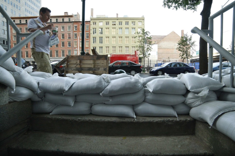 A pedestrian passes next to sandbags used to control possible floods at downtown Manhattan in New York