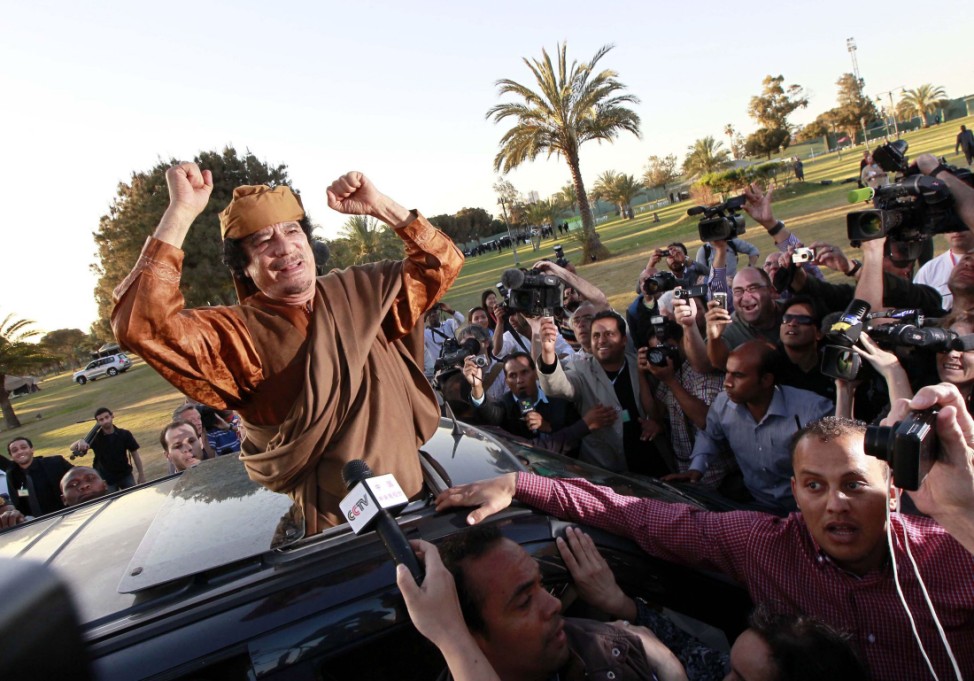 File photo of Gaddafi gesturing from a car in Tripoli