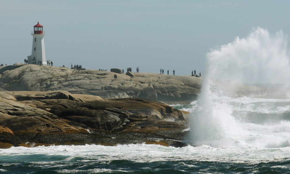 Waves created by the passing of Hurricane Irene crash over the rocks near the lighthouse at Peggy's Cove, Nova Scotia