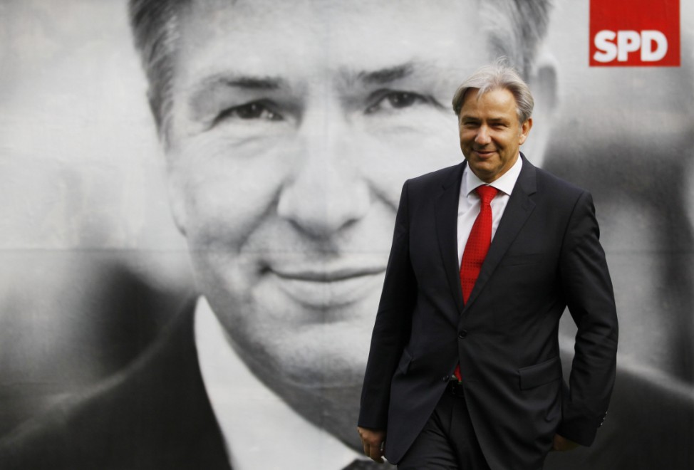 Berlin Mayor Wowereit poses in front of his election poster after it was unveiled to journalists in Berlin