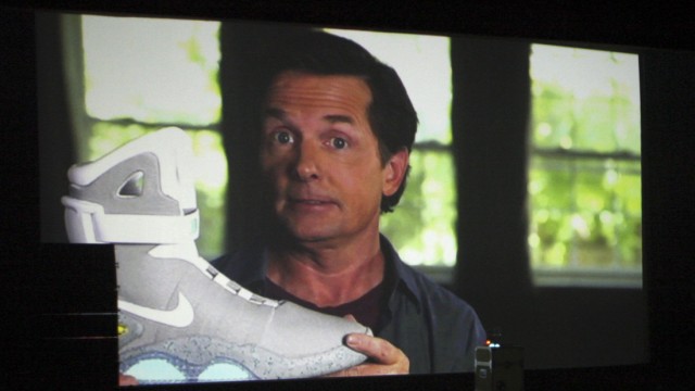 Actor Michael J. Fox is seen during a video message holding a 2011 NIKE MAG shoe, based on the original NIKE MAG worn in 2015 by his 'Back to the Future' character Marty McFly, at the shoe's unveiling at The Montalban Theatre in Hollywood