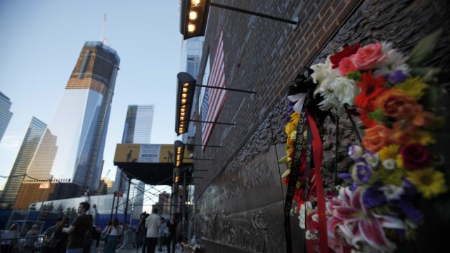 A flower wreath leans against the memorial wall at New York City Firehouse #10, which is directly across from Ground Zero and the new World Trade Center building, in New York
