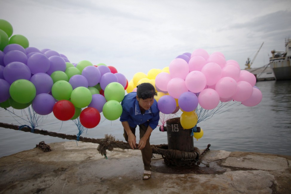 A woman prepares balloons before the departure ceremony of the Mangyongbyong cruise ship in the port area of North Korean Special Economic Zone of Rason City