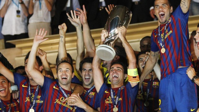 Barcelona's captain Xavi Hernandez holds the trophy as they celebrate their victory against Porto in their European Super Cup soccer match at Louis II stadium in Monaco
