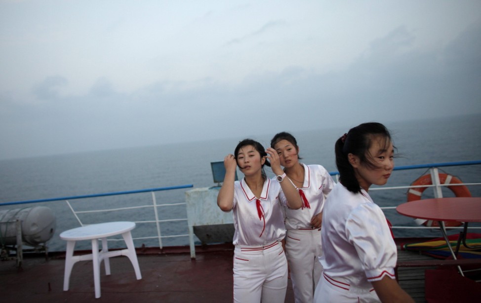 Workers of the Mangyongbyong cruise ship stand on deck, near Mount Kumgang resort