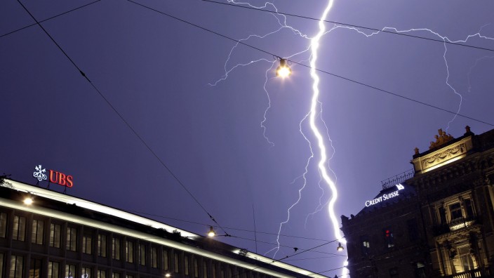 Lightning strikes over the headquarters of Swiss banks UBS and Credit Suisse during a thunderstorm over the Paradeplatz square in Zurich