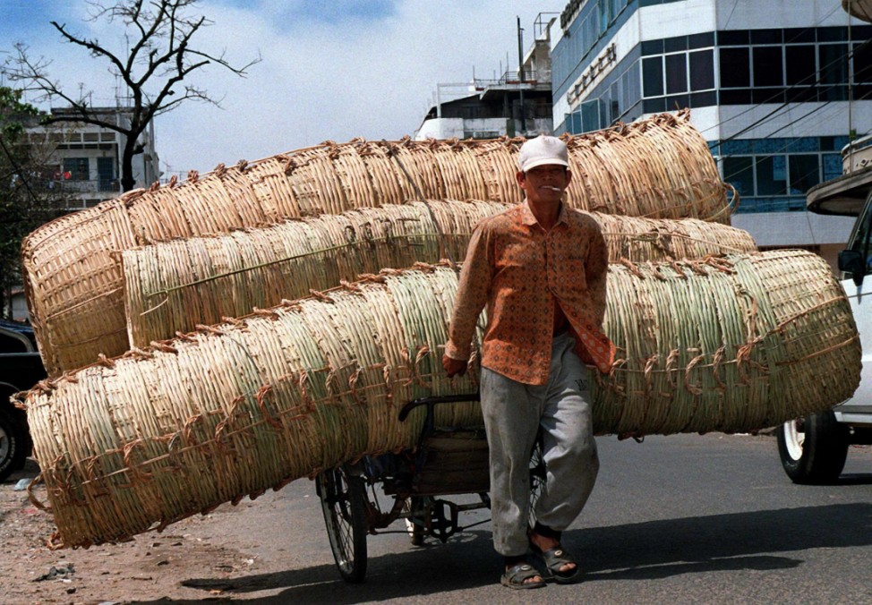 Überladene Gefährte: Korbhändler in Kambodscha