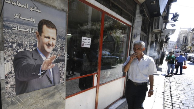Aufstand in Syrien: In einer Straße von Damaskus ist ein Porträt des syrischen Präsidenten Assad zu sehen. Das syrische Regime ist nun selbst Opfer von Hackerangriffen geworden.