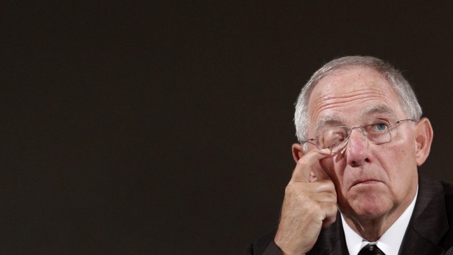 German Finance Minister Schaeuble wipes face during International Meeting of Prayer for Peace in Munich