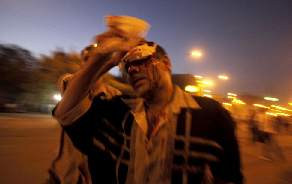 A Christians protester is injured during a clash with riot policemen in Cairo