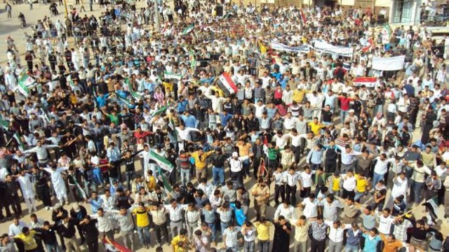 Demonstrators protesting against Syria's President Bashar al-Assad march through the streets after Friday prayers in Homs