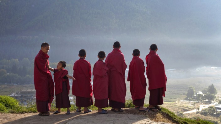 Novice monks at the Dechen Phrodrang Buddhist monastery look down from a hilltop in Bhutan's capital Thimphu