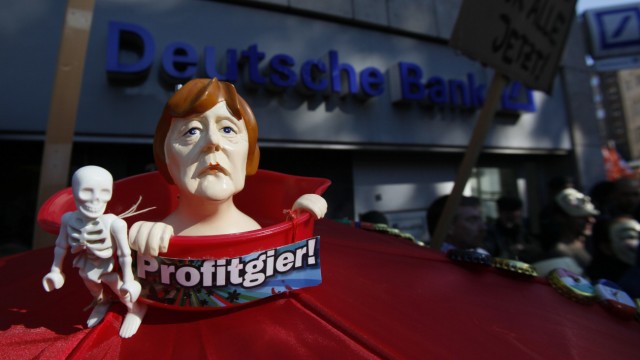 A figure of German Chancellor Merkel is pictured during a protest of several hundred people against banking and finance in front of a branch of Germany's largest bank 'Deutsche Bank' in Cologne
