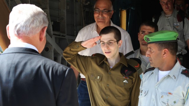 Rückkehr des entführten Soldaten nach Israel: Der heimgekehrte Soldat Gilad Schalit (Mitte) salutiert Israels Regierungschef Benjamin Netanjahu auf dem Militärflughafen Tel Nov.