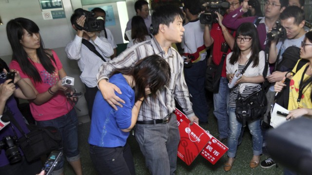 Unfallvideo aus China: Abgefilmte Trauer: Die Eltern der kleinen Yue Yue (Mitte) werden im Krankenhaus von der Presse belagert.