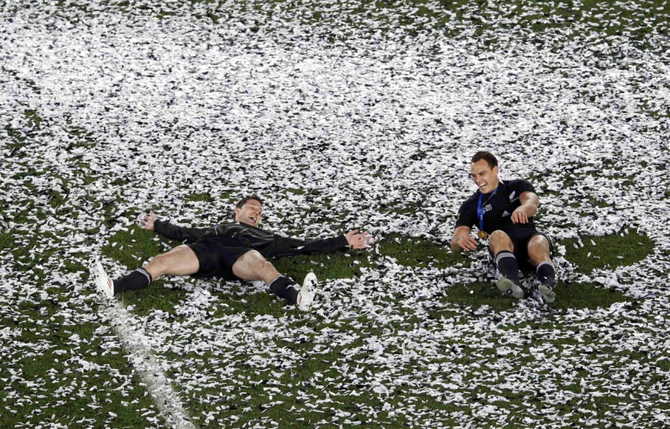 New Zealand All Blacks' Cory Jane and Israel Dagg make 'snow angels' in confetti as they celebrate beating France to win the Rugby World Cup final at Eden Park in Auckland