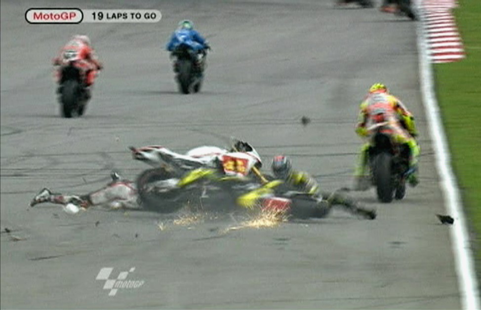 Honda MotoGP rider Simoncelli of Italy is seen on the ground during a crash involving Yamaha's Edwards of the U.S and Ducati's Rossi of Italy at the Malaysian MotoGP in Sepang