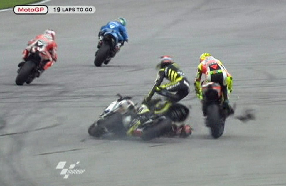 Honda MotoGP rider Simoncelli of Italy is seen on the ground during a crash involving Yamaha's Edwards of the U.S and Ducati's Rossi of Italy at the Malaysian MotoGP in Sepang