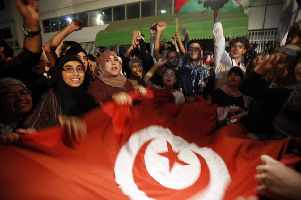 Supporters of the Islamist Ennahda movement celebrate outside Ennahda's headquarters in Tunis