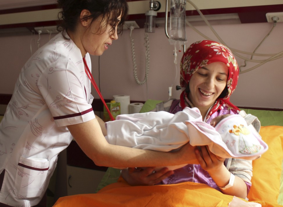 Earthquake survivor Semiha Karaduman holds her two-week old baby girl Azra at a hospital in Ankara