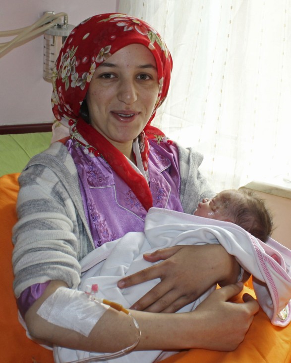 Earthquake survivor Semiha Karaduman holds her two-week old baby girl Azra at a hospital in Ankara