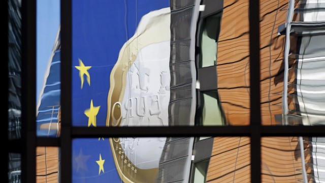 A banner showing a Euro coin is reflected on the facade of the European Commission headquarters in Brussels