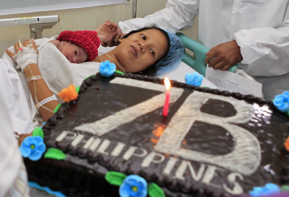UNFPA staff gives a cake to the family of a newborn baby girl in Manila