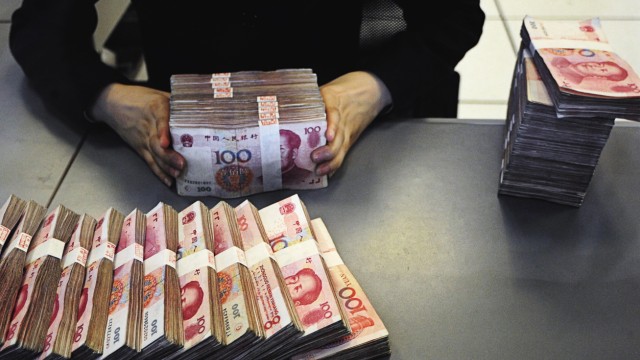 An employee counts yuan banknotes at a branch of the Pudong Development Bank in Hefei