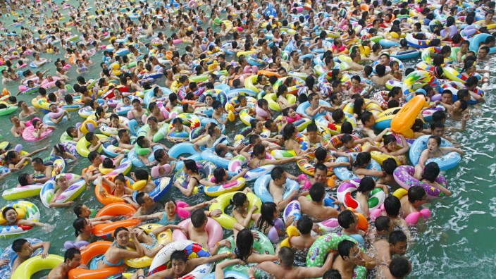 Residents crowd in a swimming pool to escape the summer heat during a hot weather spell in Daying county of Suining
