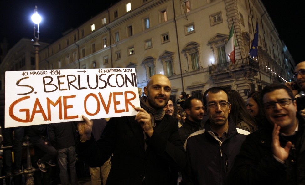A man holds a placard against Italian Prime Minister Silvio Berlusconi outside Chigi palace in Rom