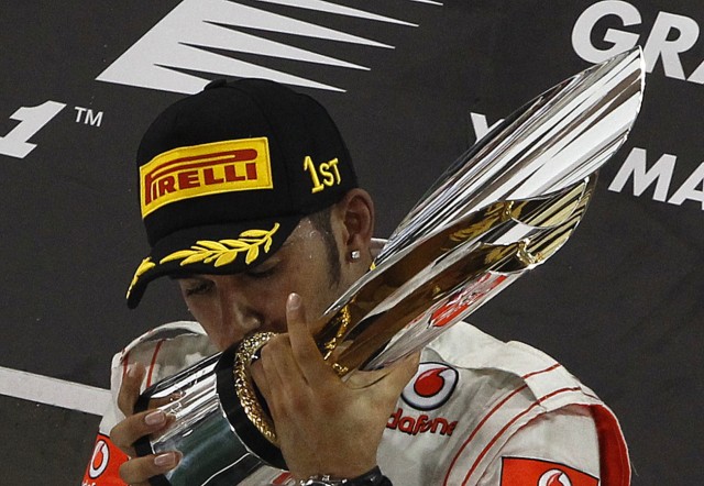 McLaren Formula One driver Lewis Hamilton of Britain poses with the trophy during the Abu Dhabi F1 Grand Prix at Yas Marina circuit in Abu Dhabi