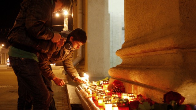 Men light candles near the metro station Oktyabrskaya in central Minsk